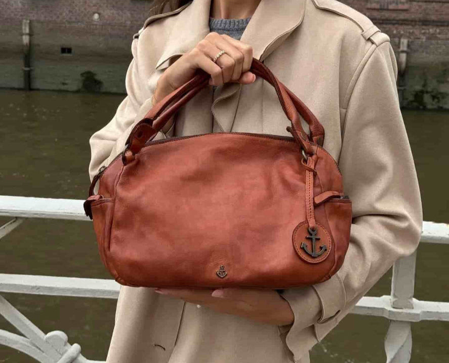 Frau mit Handtasche aus Leder Modell Saphira in Cognac