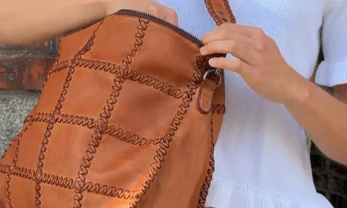 Frau kramt in Shopper aus Leder