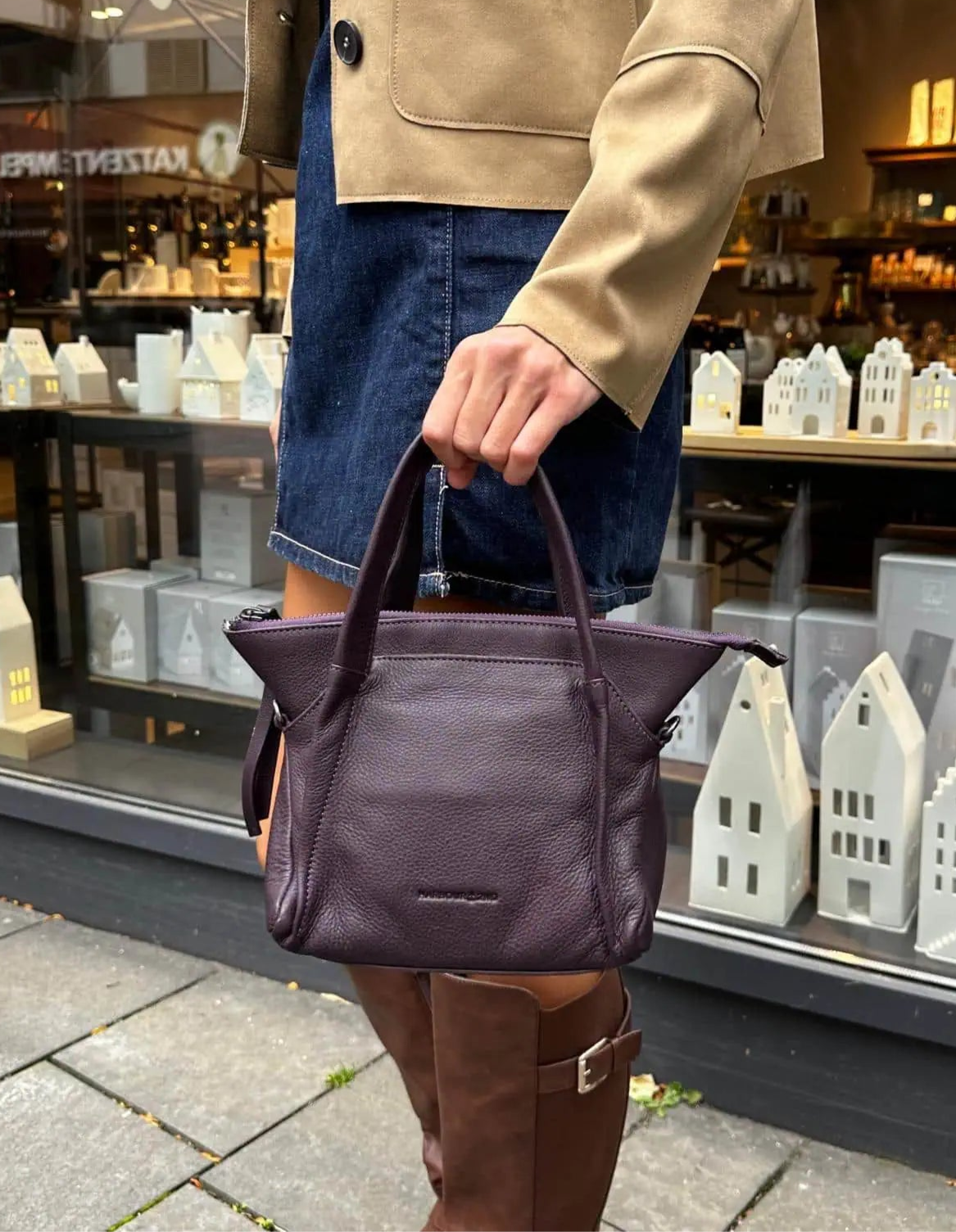 Frau mit Handtasche aus Leder Modell Thea in Purple