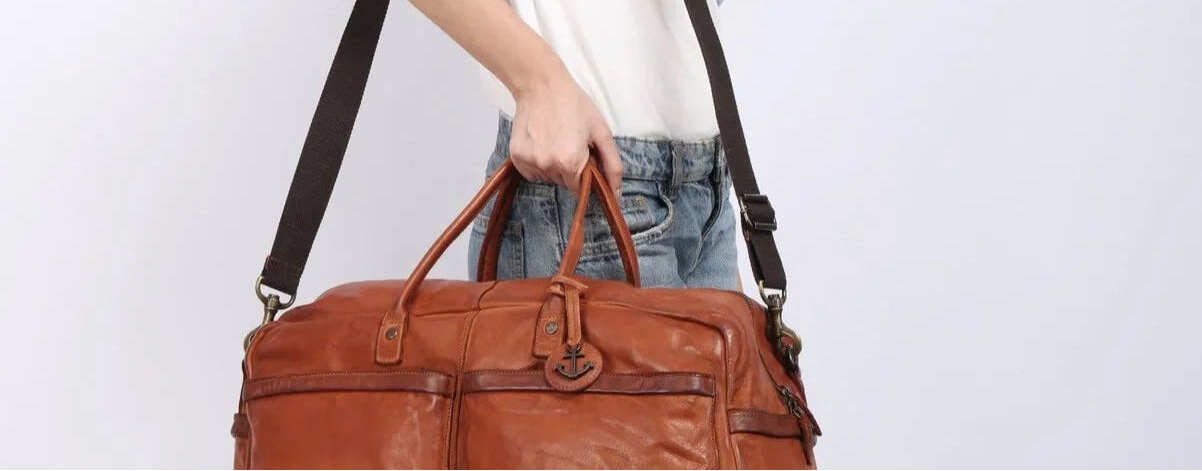 Frau trägt Reisetasche aus Leder Modell Theron in Cognac